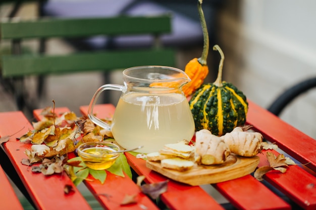 Foto té de jengibre con limón, miel y decoración otoñal.