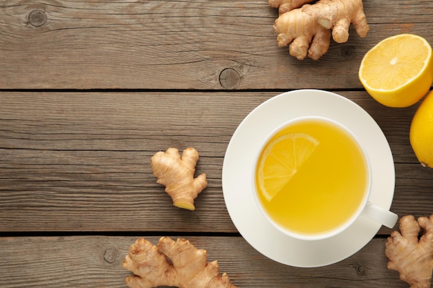 Té de jengibre con limón y miel sobre fondo de madera gris. Vista superior