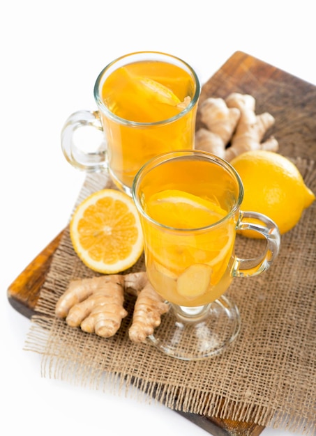 Té de jengibre con limón y miel en vaso de cristal sobre mesa de madera