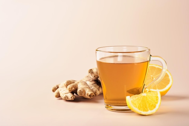 Té de jengibre Taza de té de jengibre con miel de limón y menta sobre fondo beige Concepto de medicina alternativa remedio casero natural para el resfriado y la gripe Vista superior Espacio libre para el texto