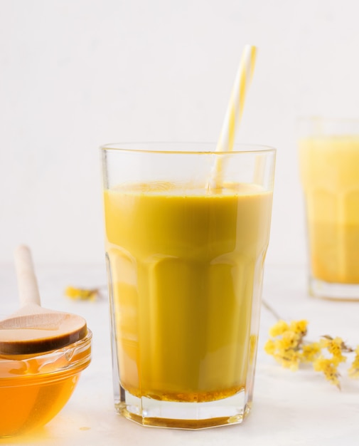 Té con leche con cúrcuma sobre fondo blanco.