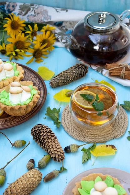 Té de limón caliente y galletas con glaseado de crema sobre una mesa de madera el enfoque selectivo