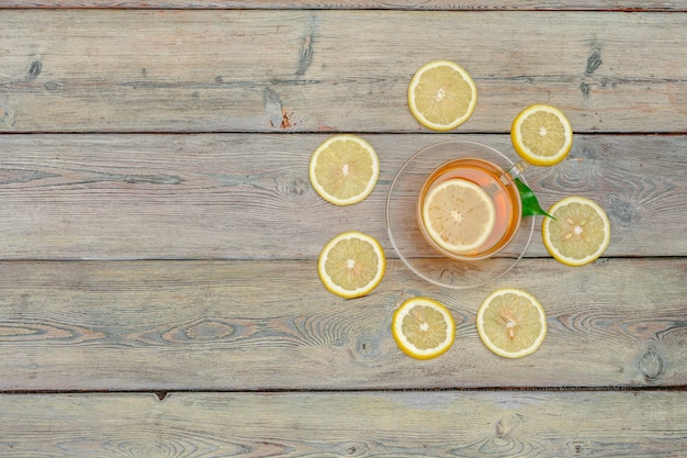 Té de limón con limón y lima en mesa de madera