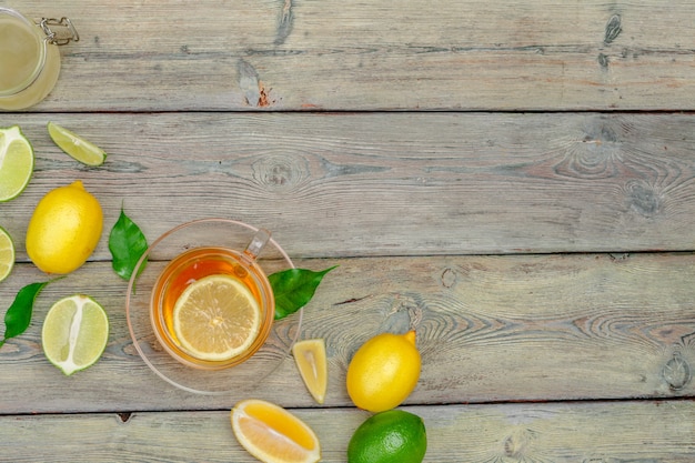 Té de limón con limón y lima en mesa de madera