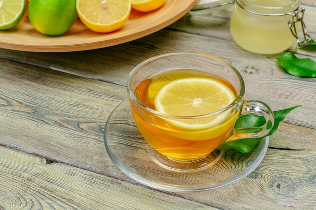 Té de limón con limón y lima en mesa de madera