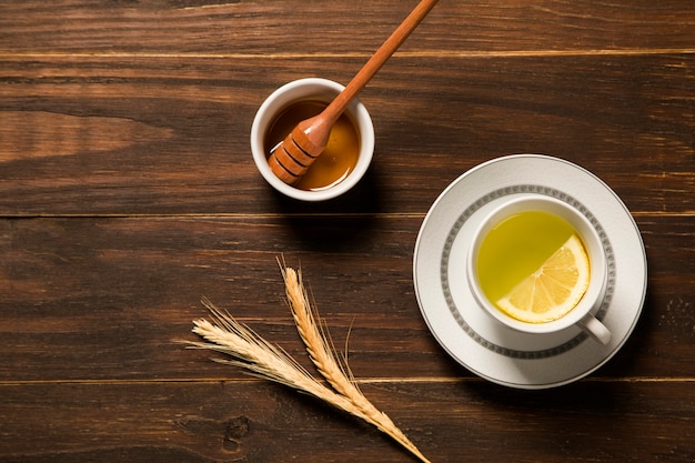 Té con limón y miel en la mesa de madera.