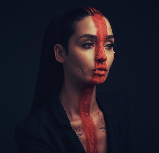 Te llamo hermosa pero eres más que increíble Foto de estudio de una mujer joven posando con pintura en la cara sobre un fondo negro