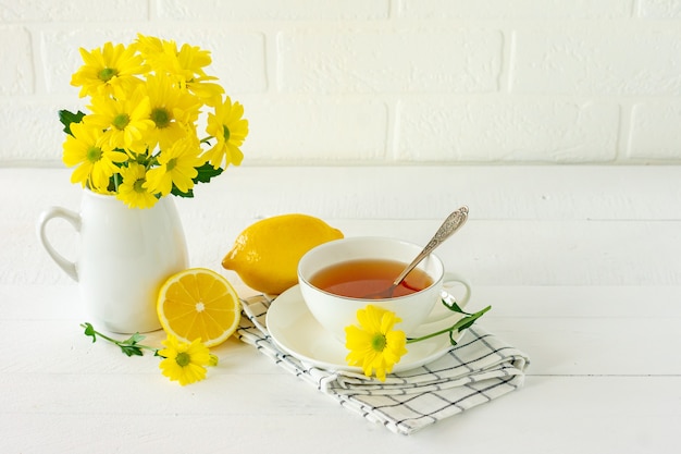 Té de la mañana con flores de crisantemo amarillo y limón.