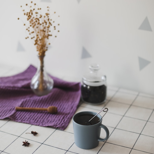 Té de la mañana con galletas de avena caseras en la mesa de la cocina con una toalla de lino púrpura