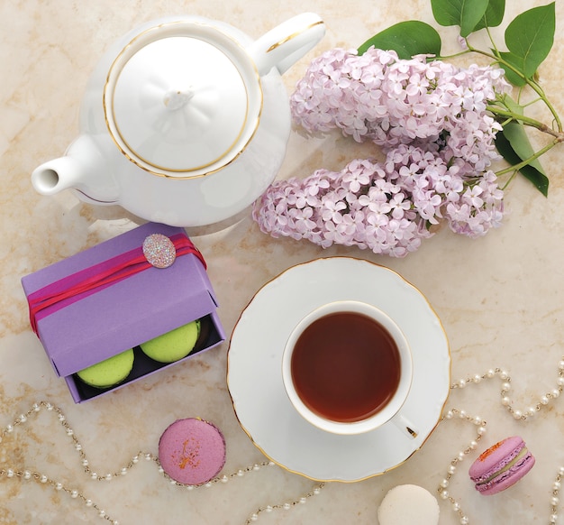 Té de la mañana con galletas, macarons y una rama de lila