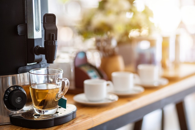 Té de máquina de café y taza de café en la decoración de la mesa de comedor