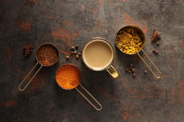 Té Masala y especias sobre fondo gris oscuro vista superior