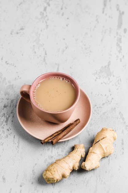 Té masala en una taza en el plato con las especias de invierno de canela y jengibre