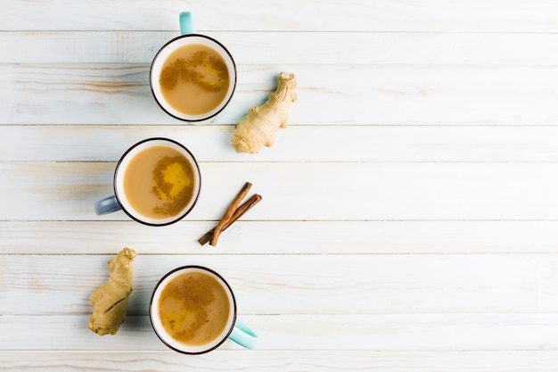 Té Masala en tazas de cerámica con las especias invernales de canela y jengibre