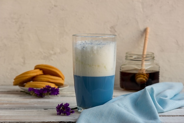 Té matcha azul en un vaso de café con leche sobre la mesa.