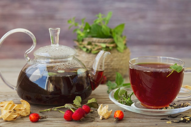 Té con menta y escaramujos y grosellas negras en un recipiente transparente. Antioxidantes, vitaminas, comida sana.