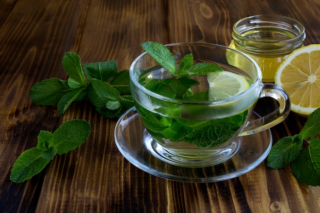 Té de menta en el vaso sobre la mesa de madera. Bebida saludable. De cerca.