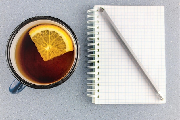 Té con naranja y un bloc de notas Concepto de creatividad otoñal Cuaderno creativo y té