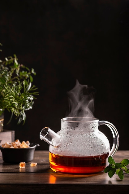 Té negro caliente con piruletas de azúcar en una mesa de madera