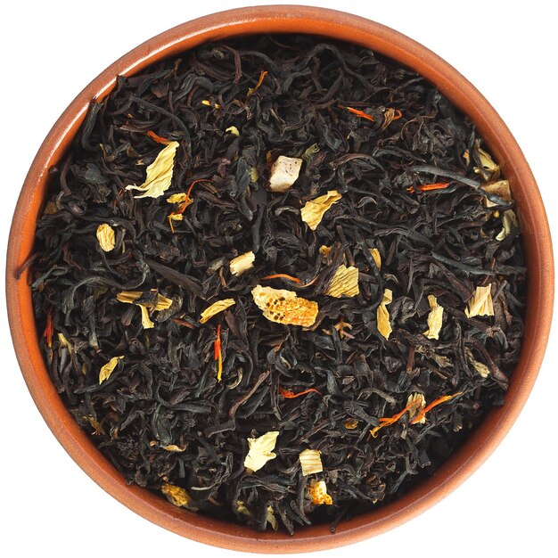 Té negro estrella oriental en un cuenco de cerámica marrón aislado sobre fondo blanco.