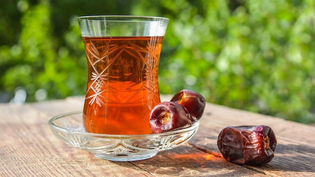 Té negro fragante en la mesa de madera en el jardín