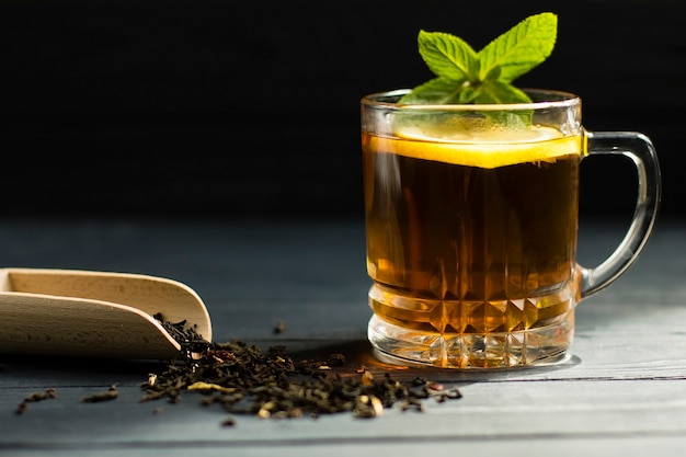 Té negro de hoja grande, con menta y limón, en una taza de vidrio.