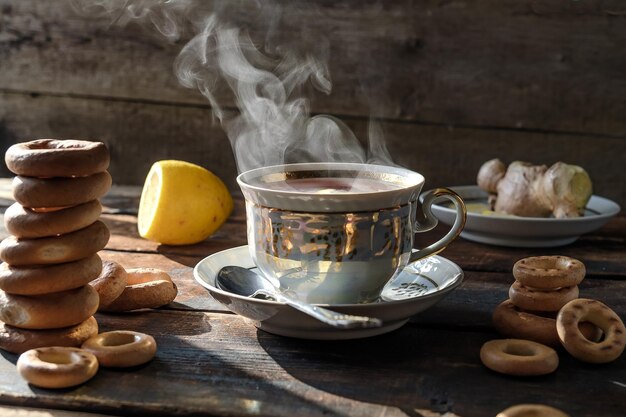 té negro con limón en una hermosa taza baja de panecillos en una mesa de madera té con panecillos