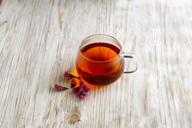 Té negro en una taza transparente junto a la espiga