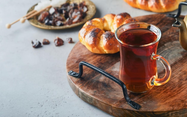 Té negro turco Taza de vidrio de té negro turco y bagel tradicional turco crujiente sobre fondo de mesa de hormigón gris Concepto de pastelería de desayuno Bebida caliente tradicional turca