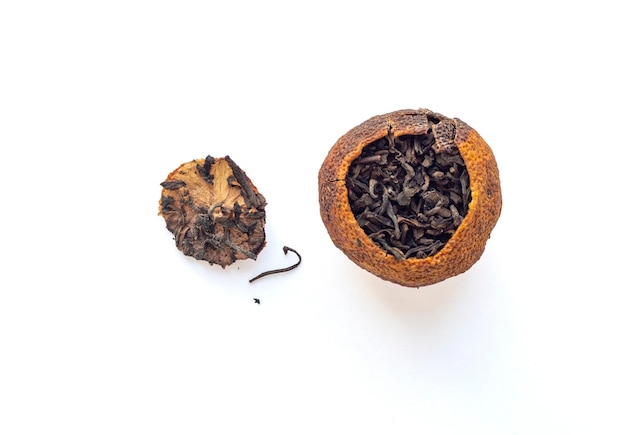 Té oscuro chino Puerh envasado en cáscara de mandarina seca aislada sobre fondo blanco