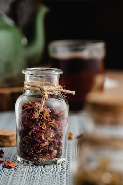 Té de rosas y hierbas en una pequeña botella de vidrio