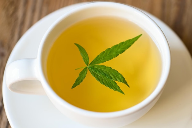 Té de salud con planta de hoja de cáñamo THC CBD hierbas comida y concepto médico Té de cannabis a base de hierbas en una taza de té con hoja de cannabis hojas de marihuana hierba