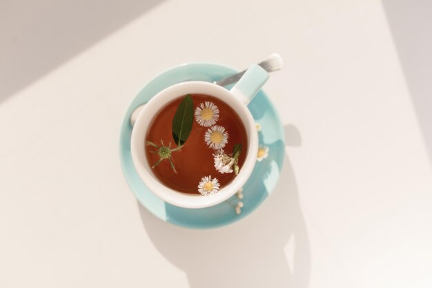 Té en una taza con flores al sol