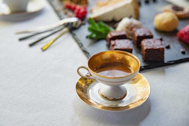 Té en una taza con un plato de postres