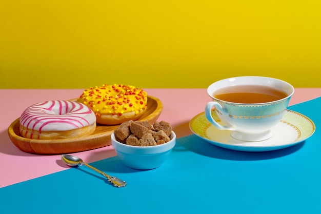 Té en una taza con postre sobre un fondo de colores brillantes