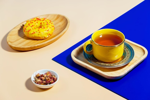 Té en una taza con postre sobre un fondo de colores brillantes