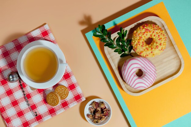 Té en una taza con postre sobre un fondo de colores brillantes