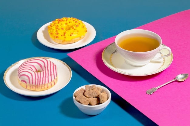 Té en una taza con postre sobre un fondo de colores brillantes