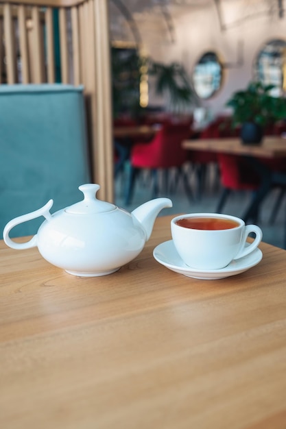 Té en una taza con una tetera sobre una mesa en un restaurante