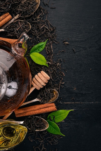 Foto té en una taza de vidrio con especias y hierbas sobre un fondo de madera negra vista superior espacio de copia