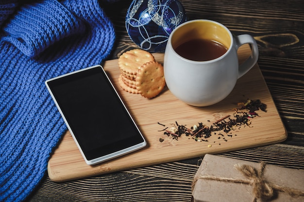 Té y teléfono inteligente en el centro de la linda decoración navideña