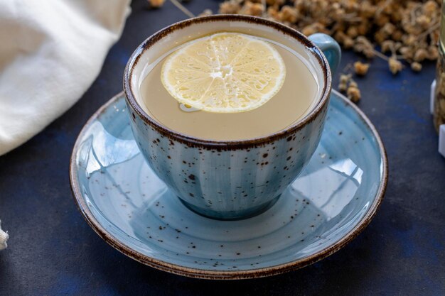 Té de tilo en una taza sobre un fondo negro y azul