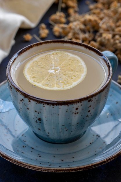 Té de tilo en una taza sobre un fondo negro y azul