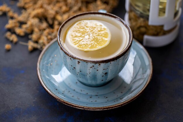 Té de tilo en una taza sobre un fondo negro y azul