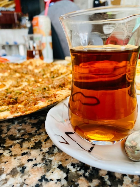 Té turco y pizza en la mesa de un restaurante