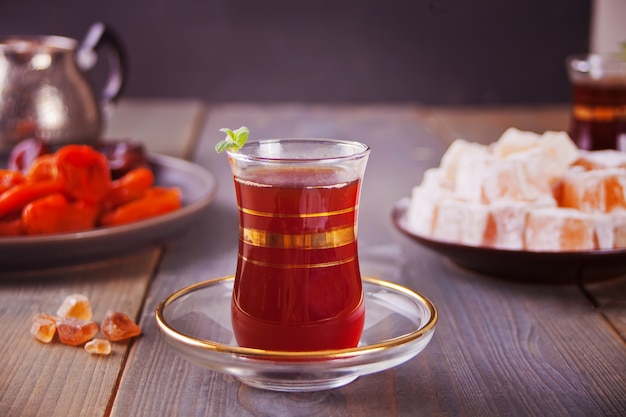 Té turco en tazas de vidrio tradicionales en la mesa de madera