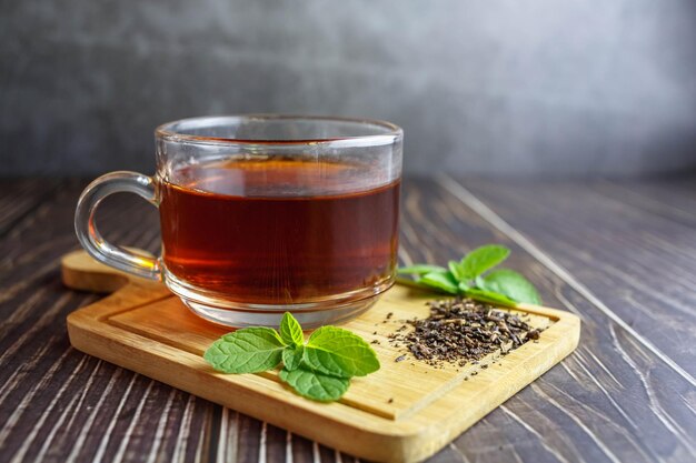 Té en vaso de vidrio sobre fondo de madera