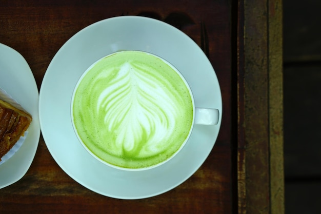 té verde caliente y pastel de plátano en el suelo de madera