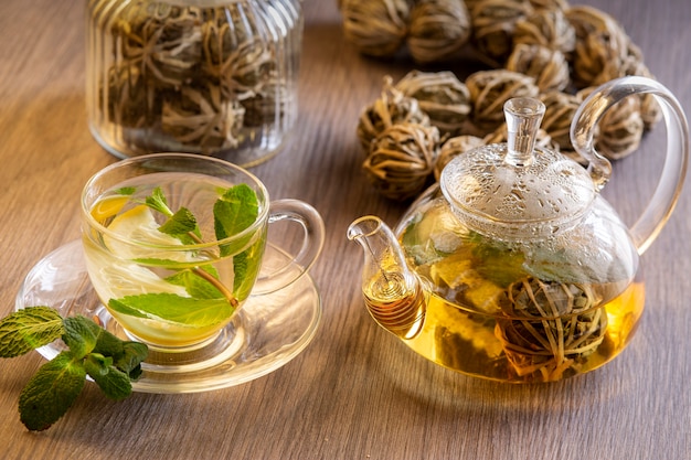 Té verde chino con limón y menta en una mesa de madera.