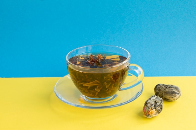 Té verde con flor de loto en la taza de cristal. De cerca. Copie el espacio.